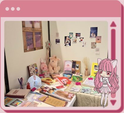 Cadre rose avec Onyx en bas à droite. Visuel de mon stand. Il est en angle contre les murs, et la papeterie est répartie sur les deux tables